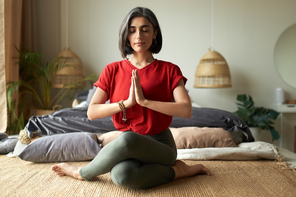 fashionable young female with grayish hair sitting gomukhasana cow pose while practicing hatha yoga bedroom after awakening keeping eyes closed pressing hands together namaste 343059 2110 reviving health